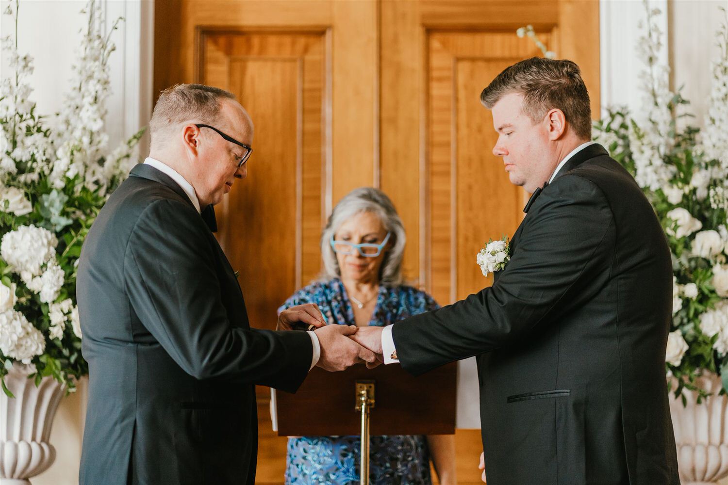 grooms exchange rings during trinity house wedding ceremony in the court room