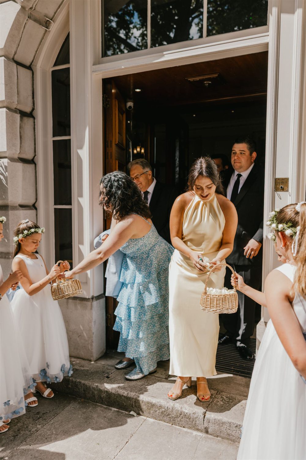 flower girls handing out confetti after wedding ceremony at trinity house in london