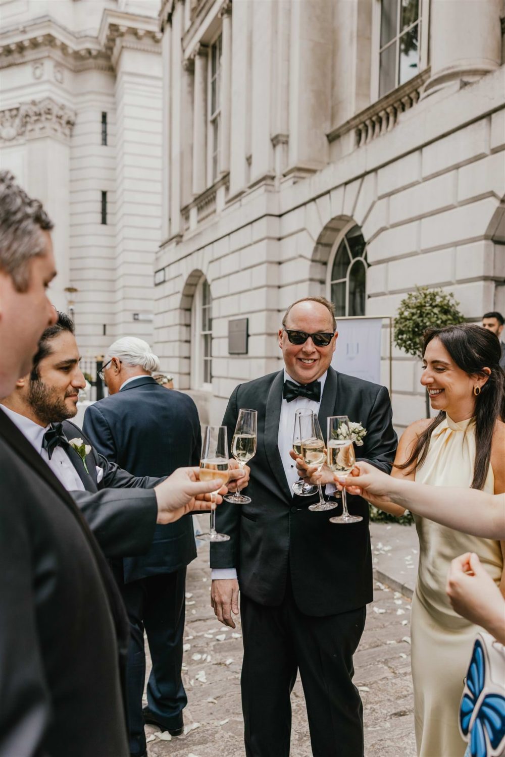 wedding guests cheers outside trinity house wedding in london