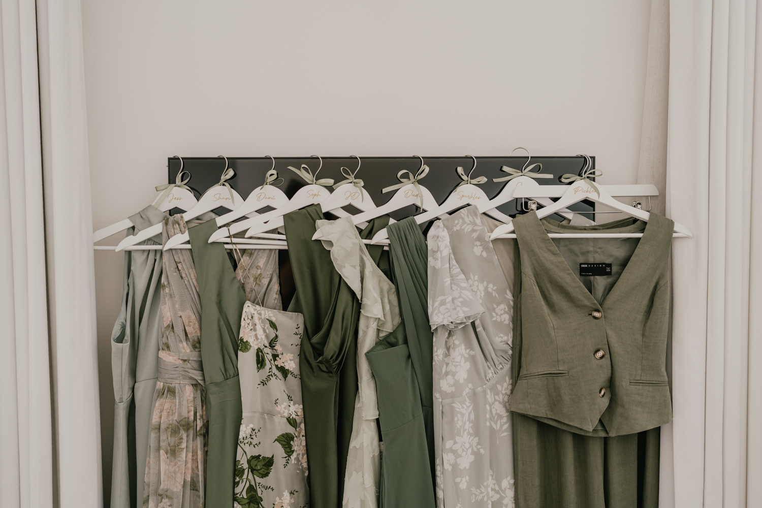 green bridal party outfits hanging up together