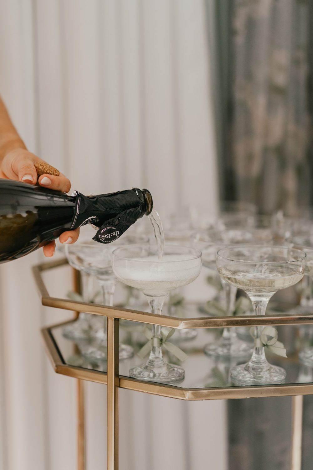 bride pouring champagne on wedding morning