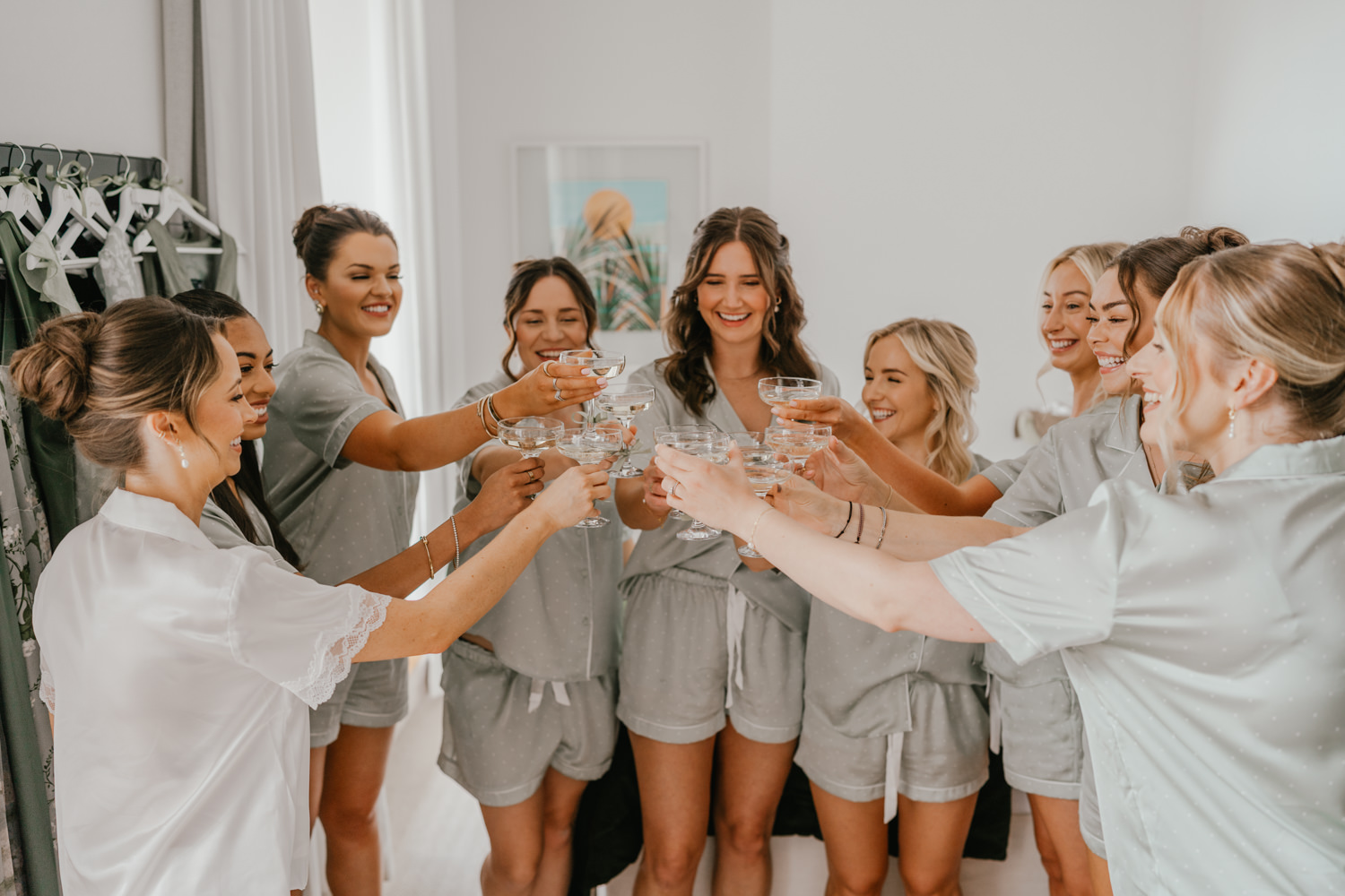 bride and bridesmaids cheers with champagne on wedding morning