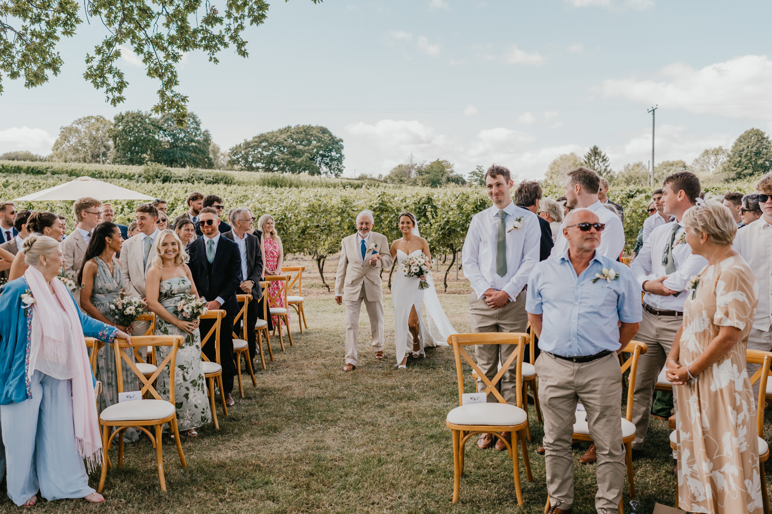bride and her father walk down the aisle at vineyard wedding ceremony at English Oak Vineyard