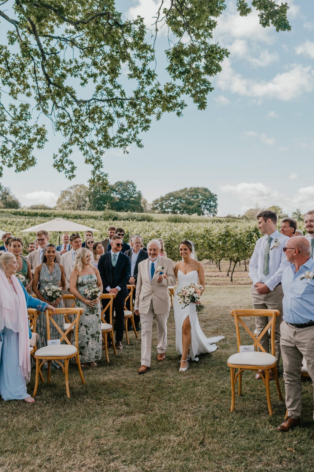bride and her father walk down the aisle at vineyard wedding ceremony at English Oak Vineyard