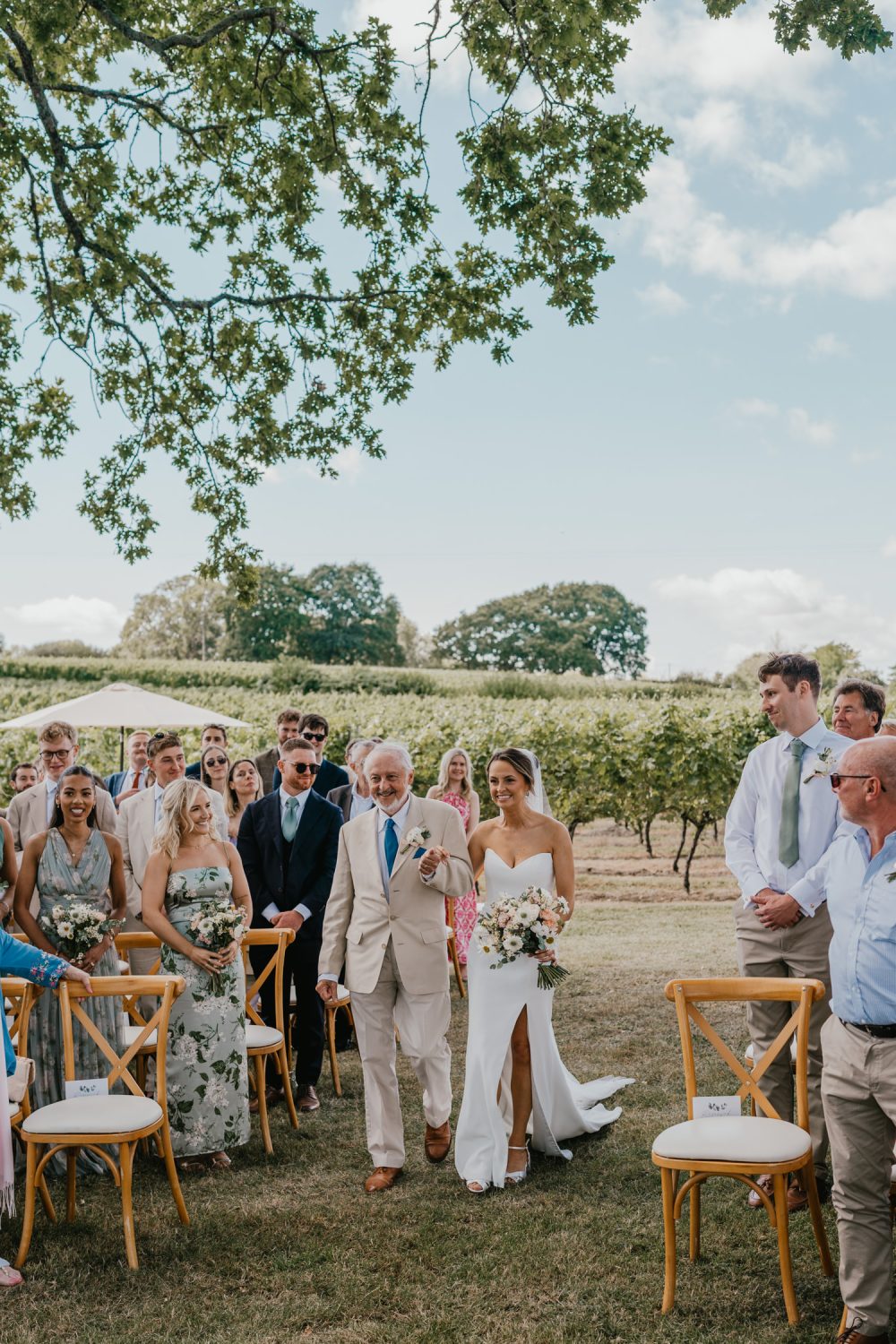 bride and her father walk down the aisle at vineyard wedding ceremony at English Oak Vineyard