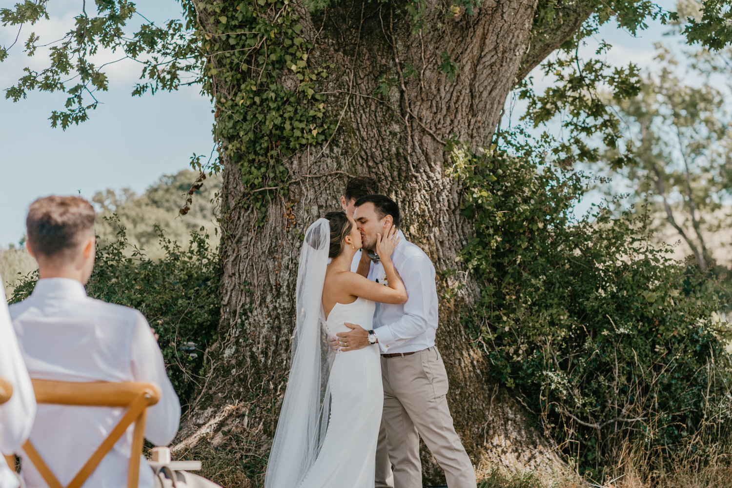 bride and groom first kiss at vineyard wedding ceremony at English Oak Vineyard