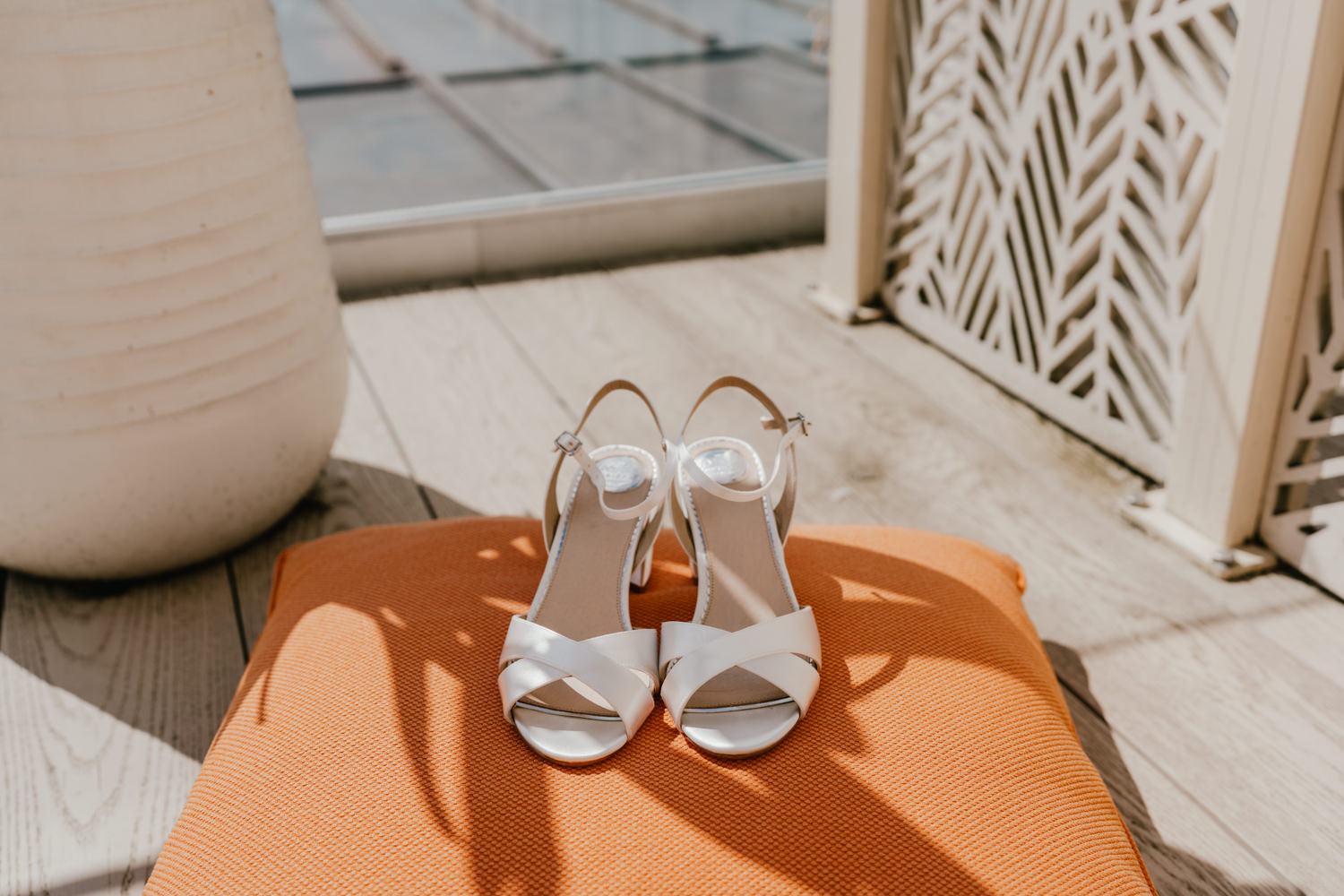 wedding shoes on an orange cushion in the sun
