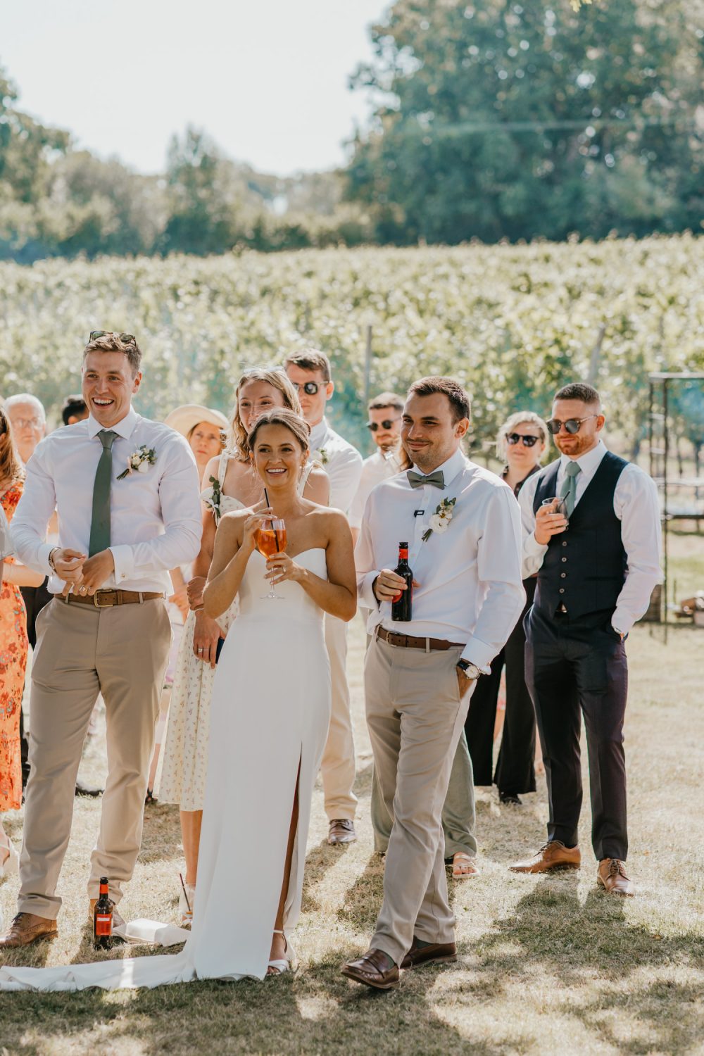 bride and groom smile during outdoor speeches at English Oak Vineyard wedding in dorset