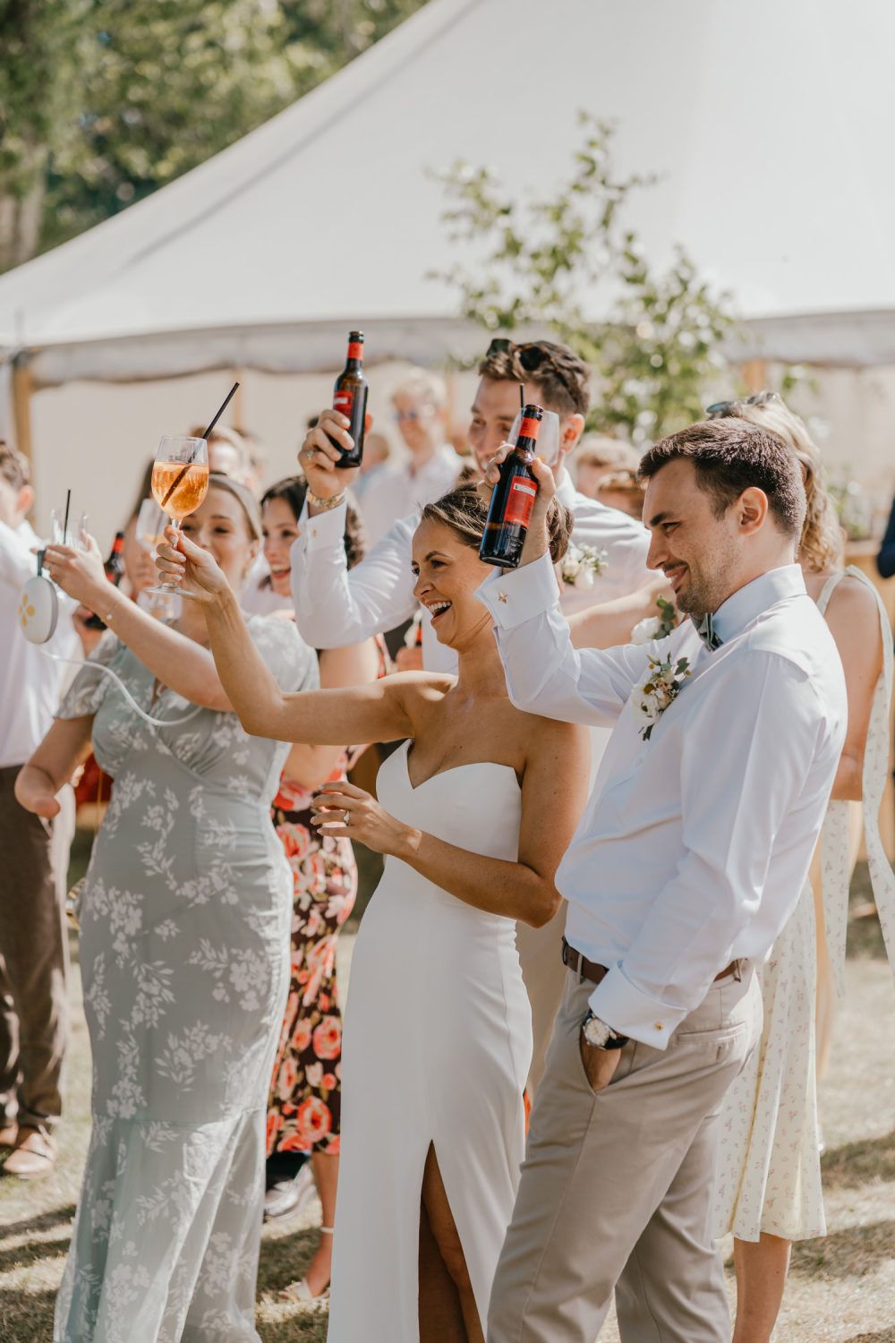 bride cheers during outdoor speeches at English Oak Vineyard wedding in dorset