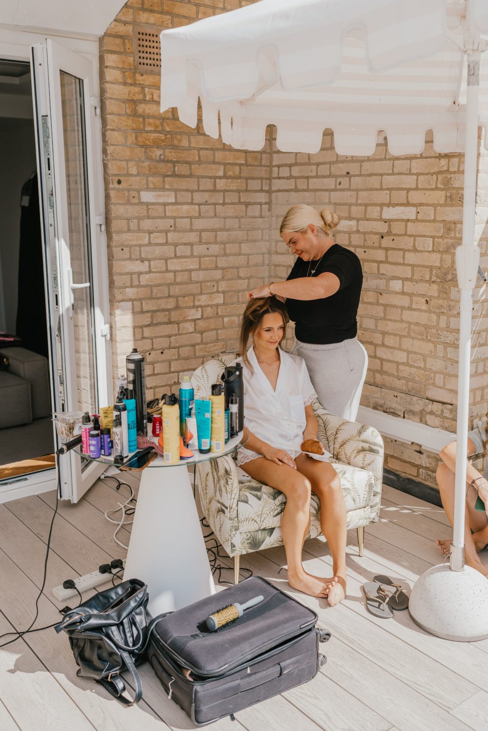 bride having her hair done on wedding morning