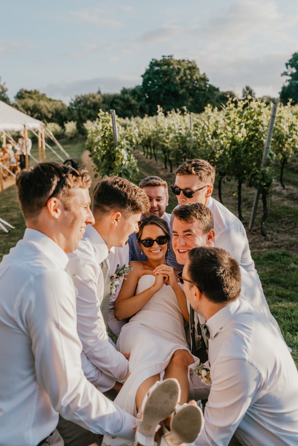 groomsmen throw the bride up in the air