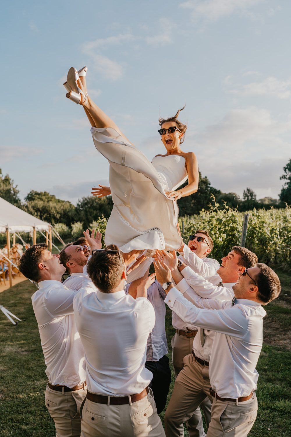 groomsmen throw the bride up in the air