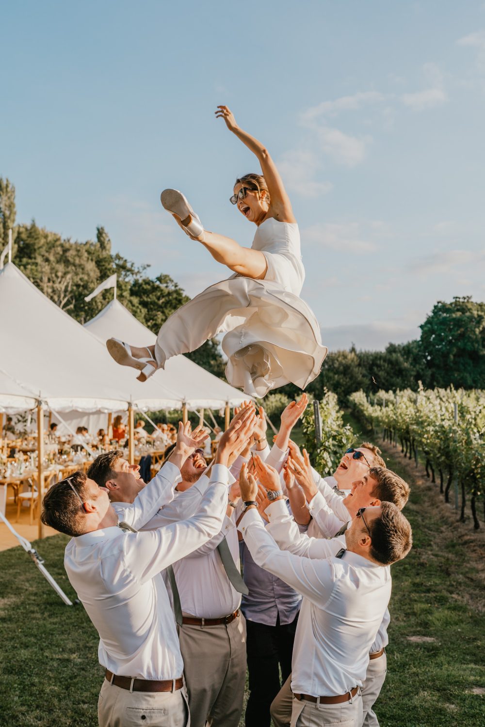 groomsmen throw the bride up in the air