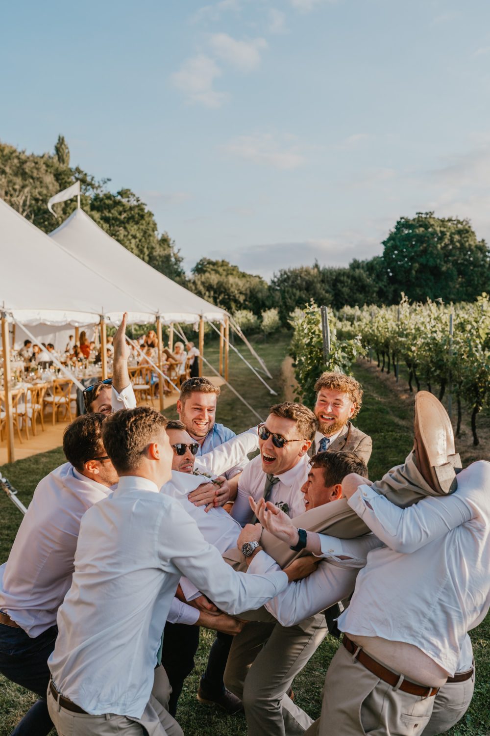 groomsmen throw the groom up in the air