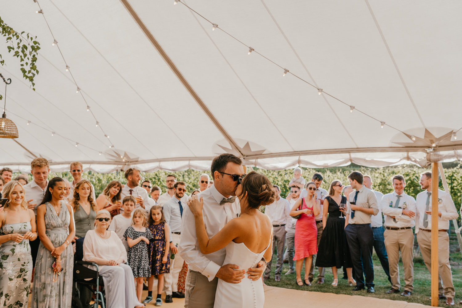 bride and groom kiss during first dance in the marquee at English Oak Vineyard wedding in Poole