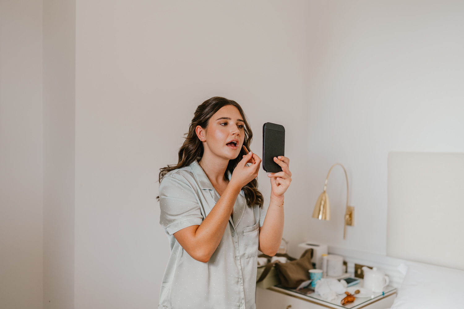 bridesmaid doing her makeup on wedding morning