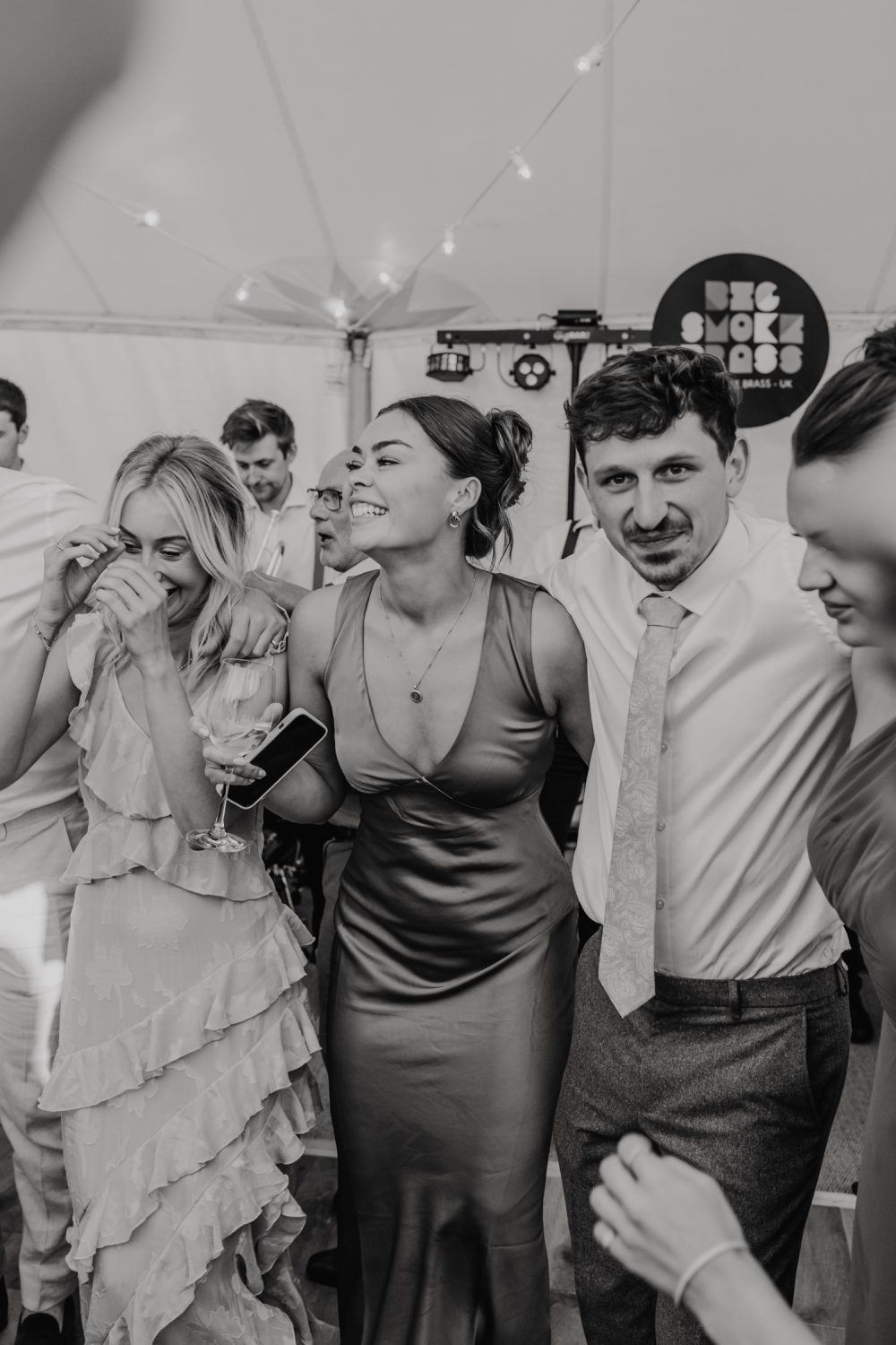 black and white photo of wedding guests on the dancefloor in the marquee at English Oak Vineyard wedding in Poole