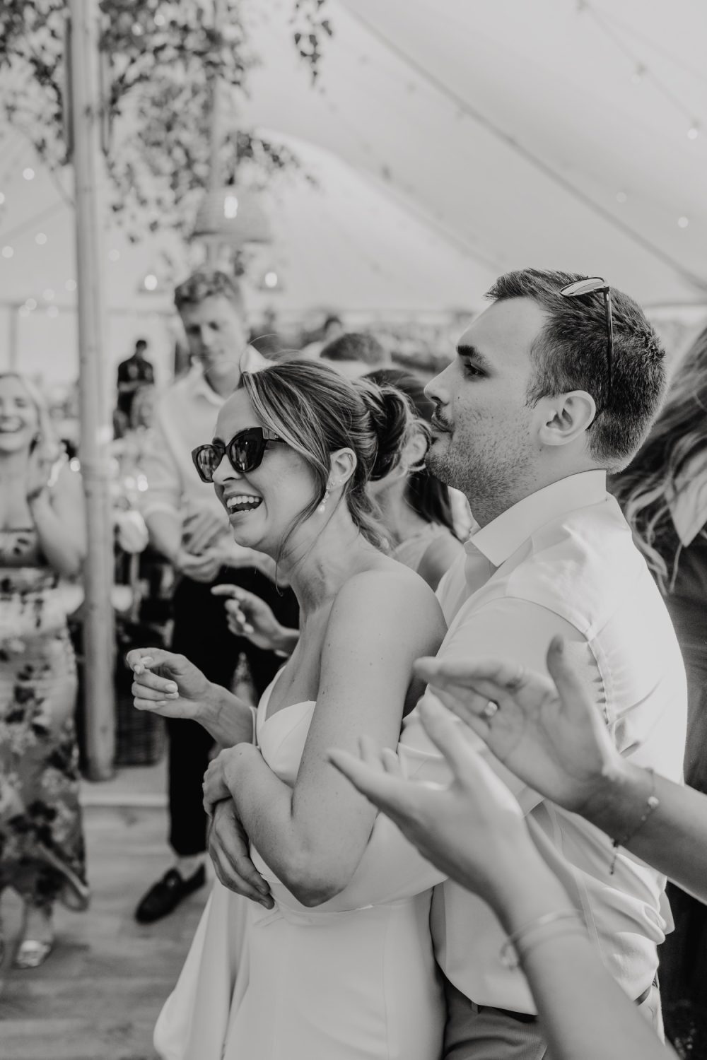 black and white photo of bride and groom cuddling on the dancefloor in the marquee at English Oak Vineyard wedding in Poole
