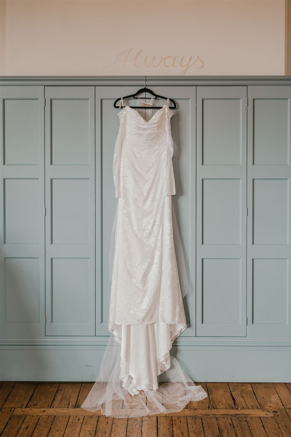 wedding dress hanging on the wall in the preparation suite at the beacon tunbridge wells wedding venue in kent