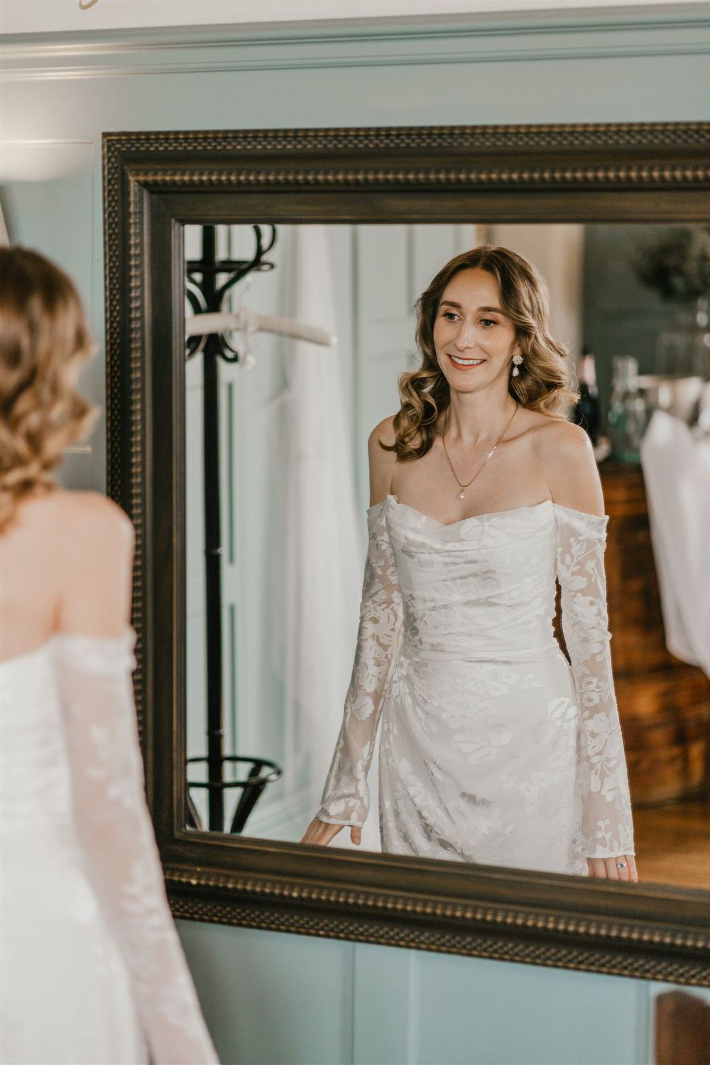 bride looks at herself in the mirror at the beacon tunbridge wells wedding
