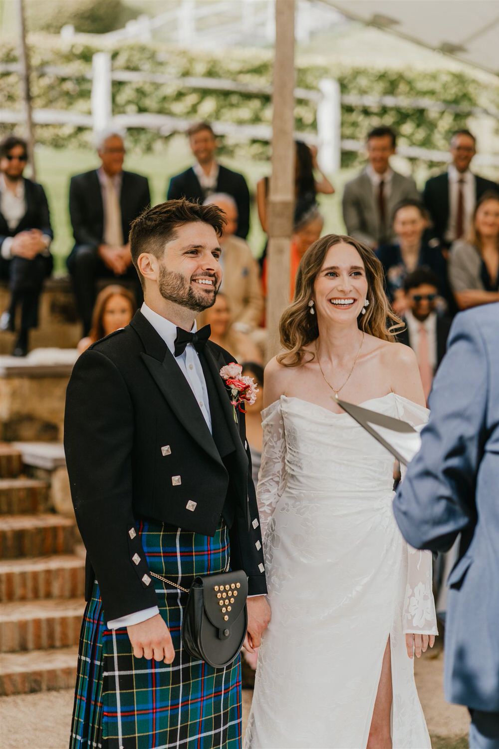 bride and groom hold hands at outdoor wedding ceremony at the beacon tunbridge wells wedding venue in kent