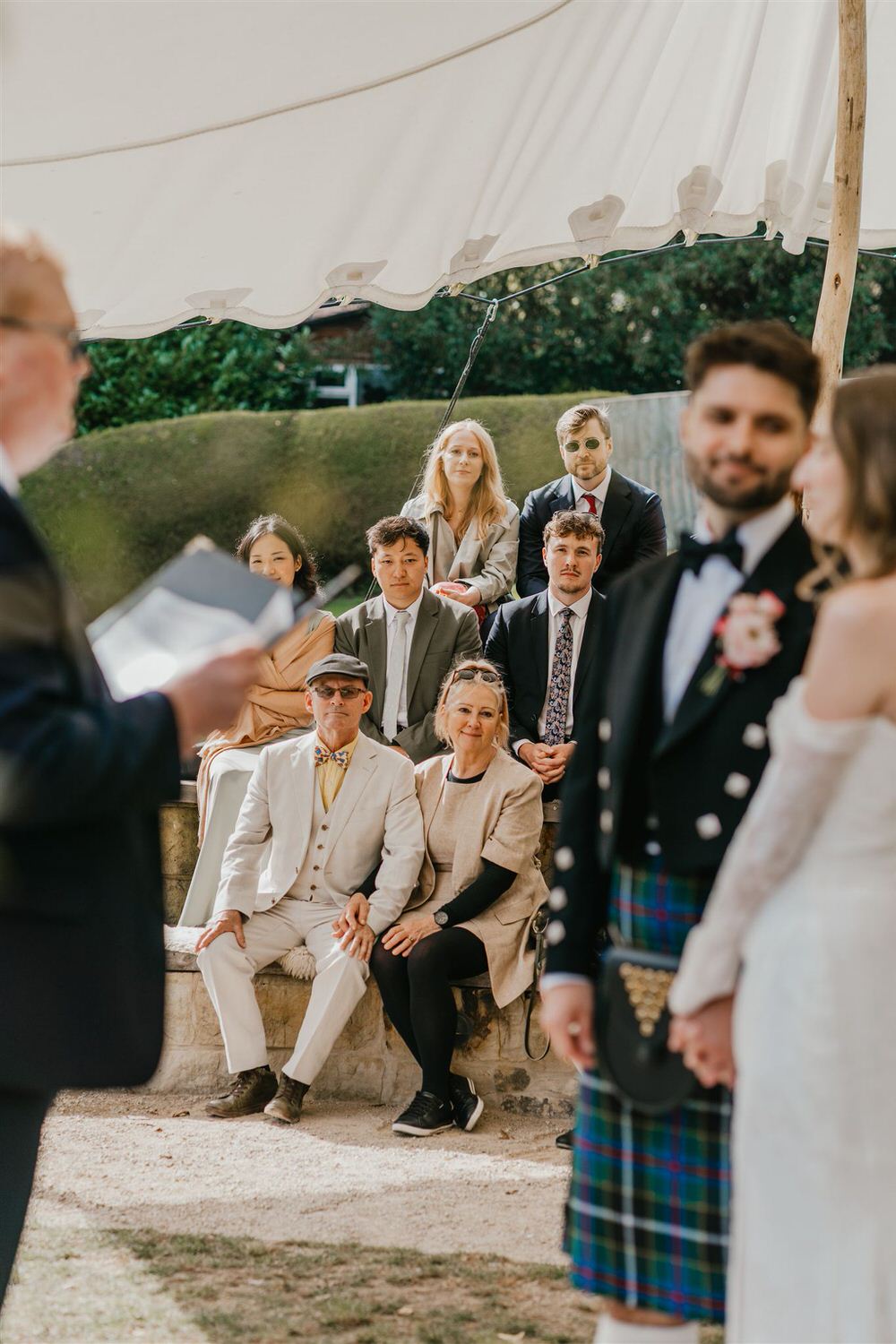 guests watch as bride and groom hold hands at the beacon tunbridge wells wedding ceremony
