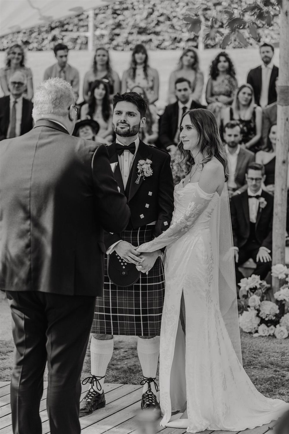 black and white photo of bride and groom holding hands at the beacon tunbridge wells wedding ceremony
