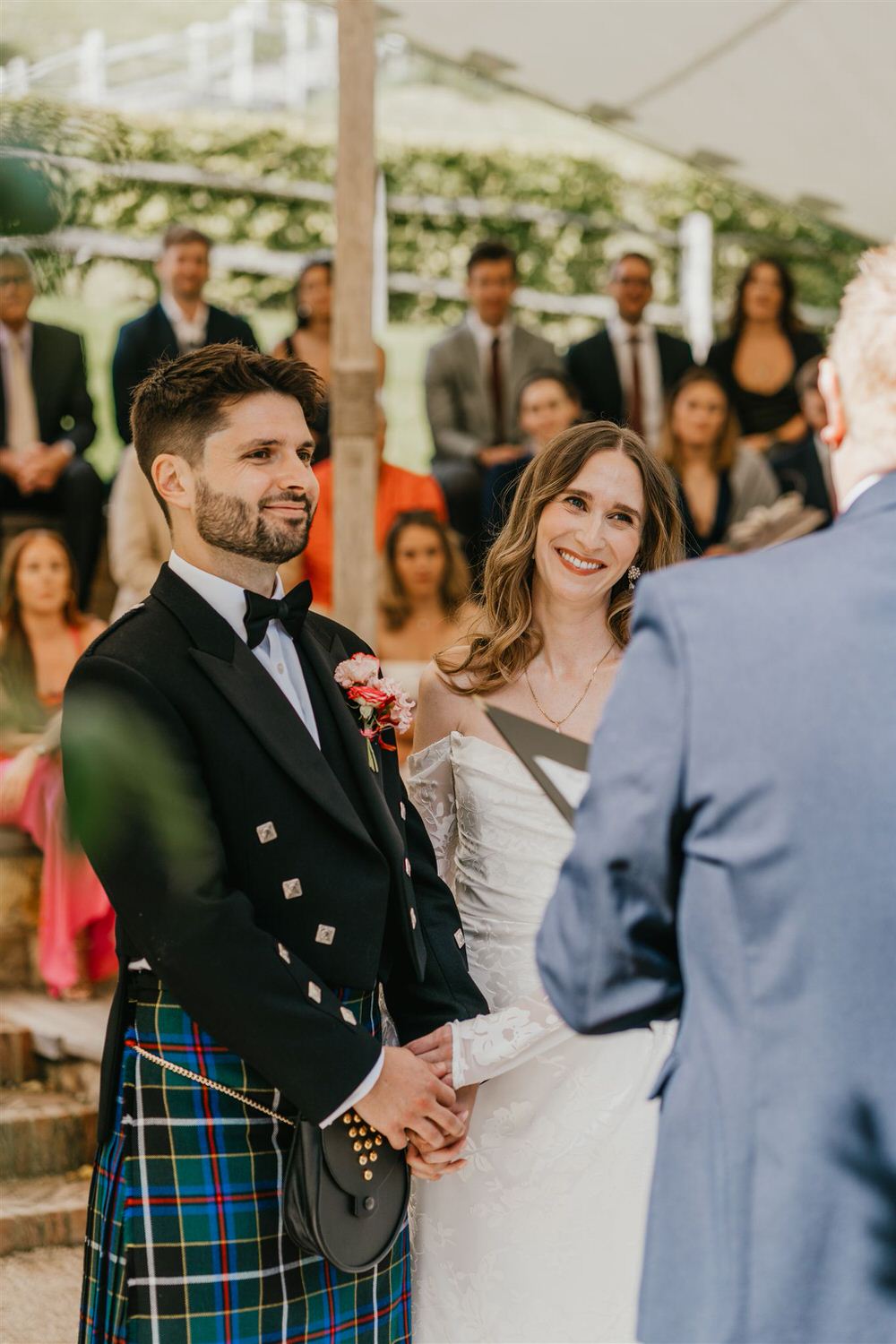 bride and groom hold hands at the beacon tunbridge wells outdoor wedding ceremony