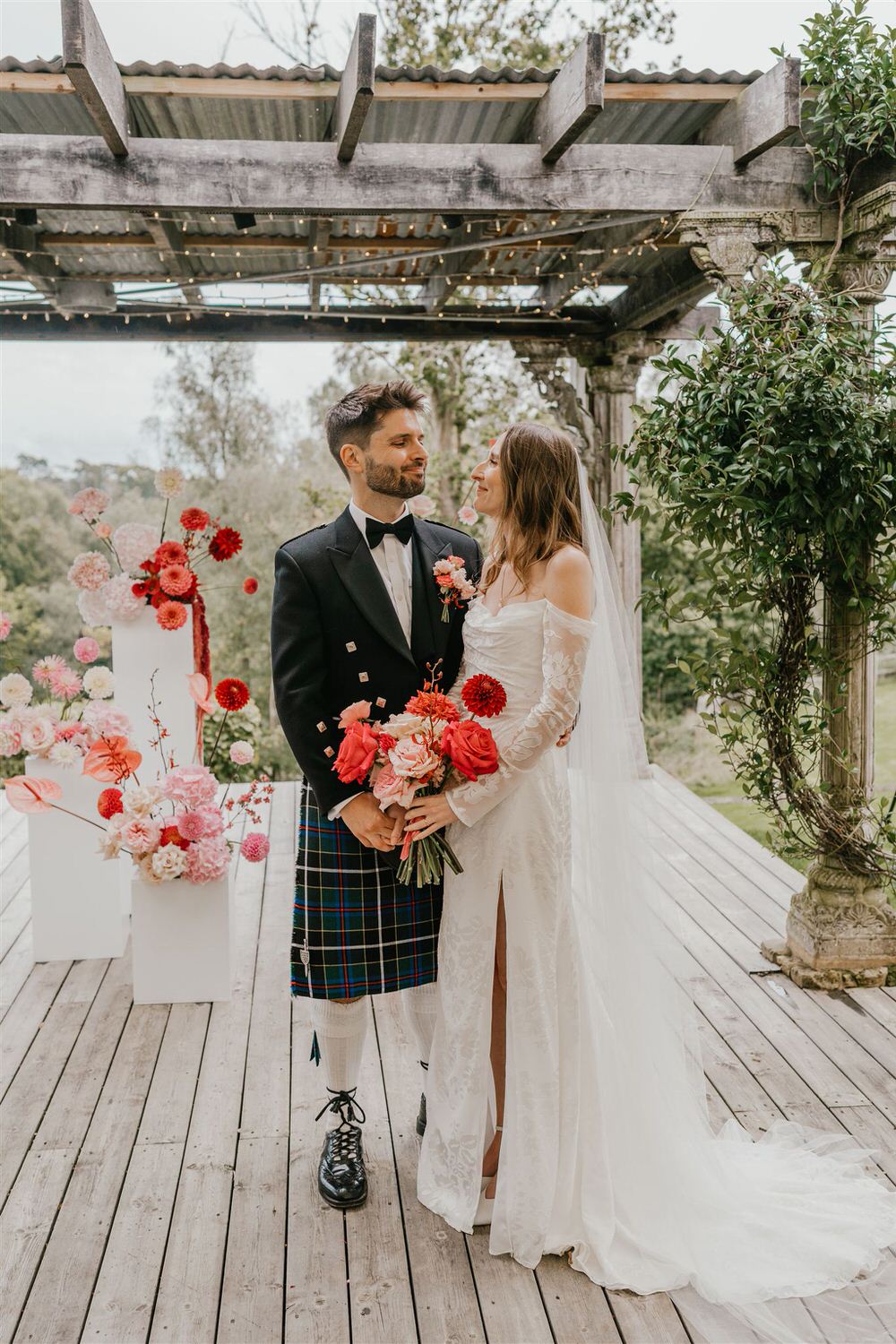 bride and groom surrounded by pink flowers at the beacon tunbridge wells wedding venue in kent