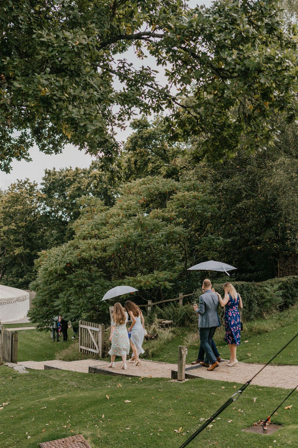 guests head to marquee in rainy wedding day at the beacon tunbridge wells