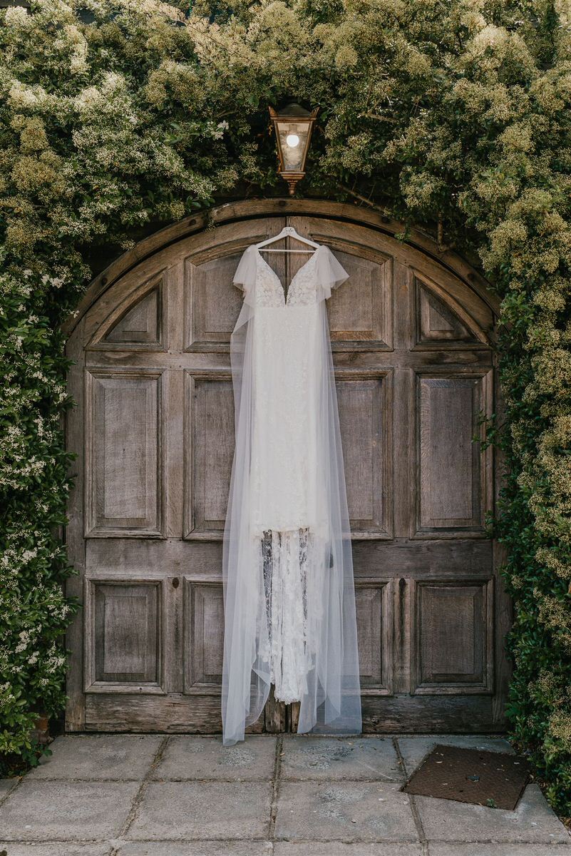 wedding dress hanging on a wooden door at winters barns wedding venue in canterbury