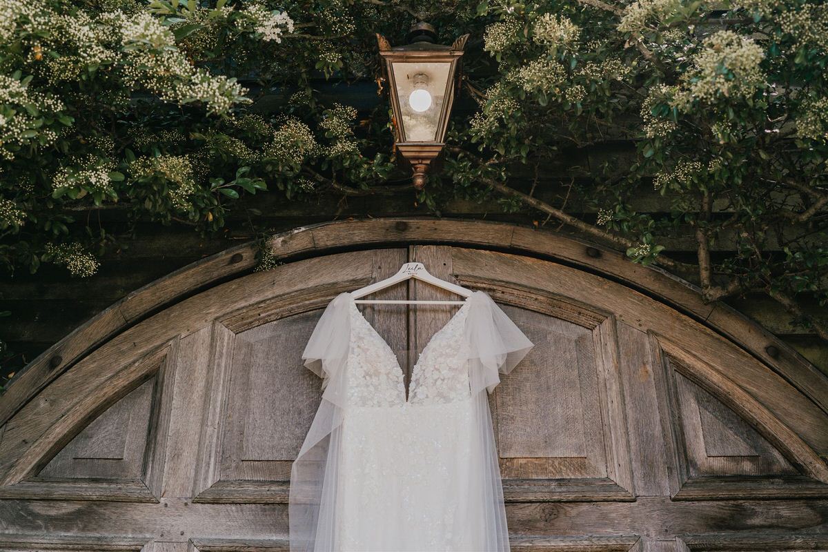 wedding dress hanging on a wooden door at winters barns wedding venue in canterbury