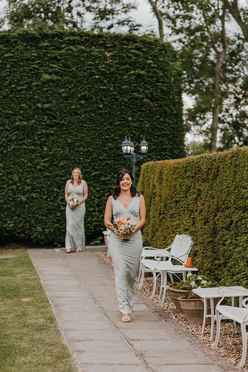 bridesmaid walking down the aisle during outdoor ceremony at winters barns wedding