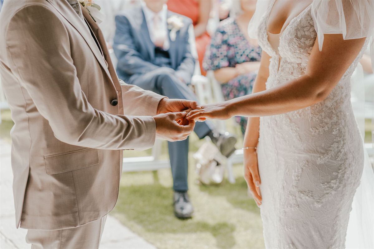 bride and groom exchange rings during outdoor winters barns wedding ceremony