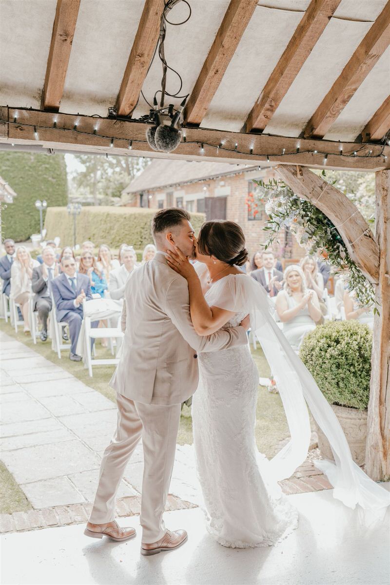 bride and groom first kiss during winters barns wedding ceremony