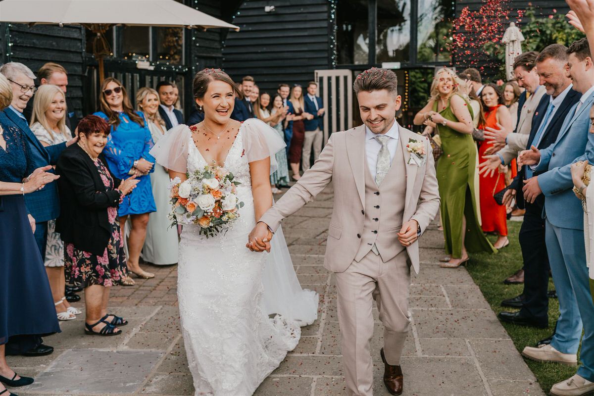 bride and groom during confetti tunnel at winters barns wedding in canterbury