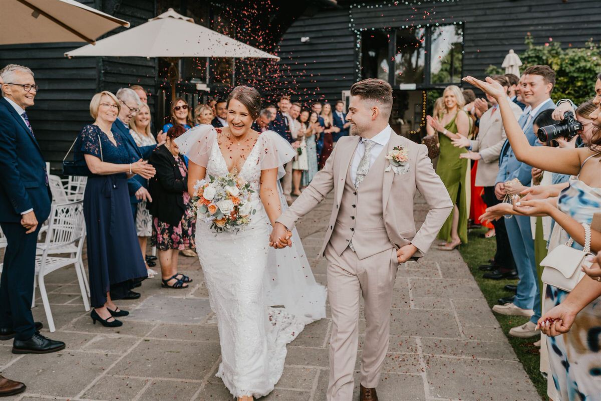 bride and groom during confetti tunnel at winters barns wedding in canterbury