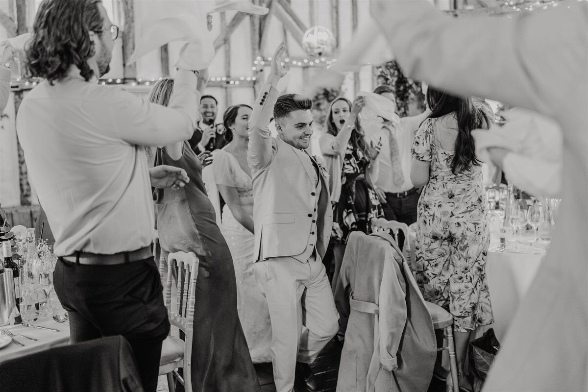 wedding guests welcome bride and groom into reception
