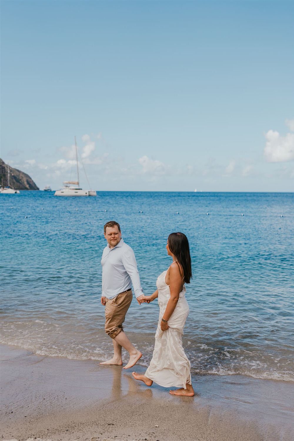 couple walking in the sea on sugar beach in saint lucia destination photography