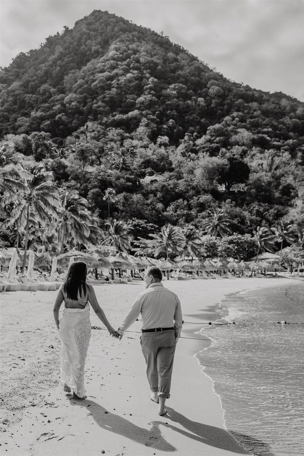 black and white photo of couple walking along sugar beach in saint lucia destination photography