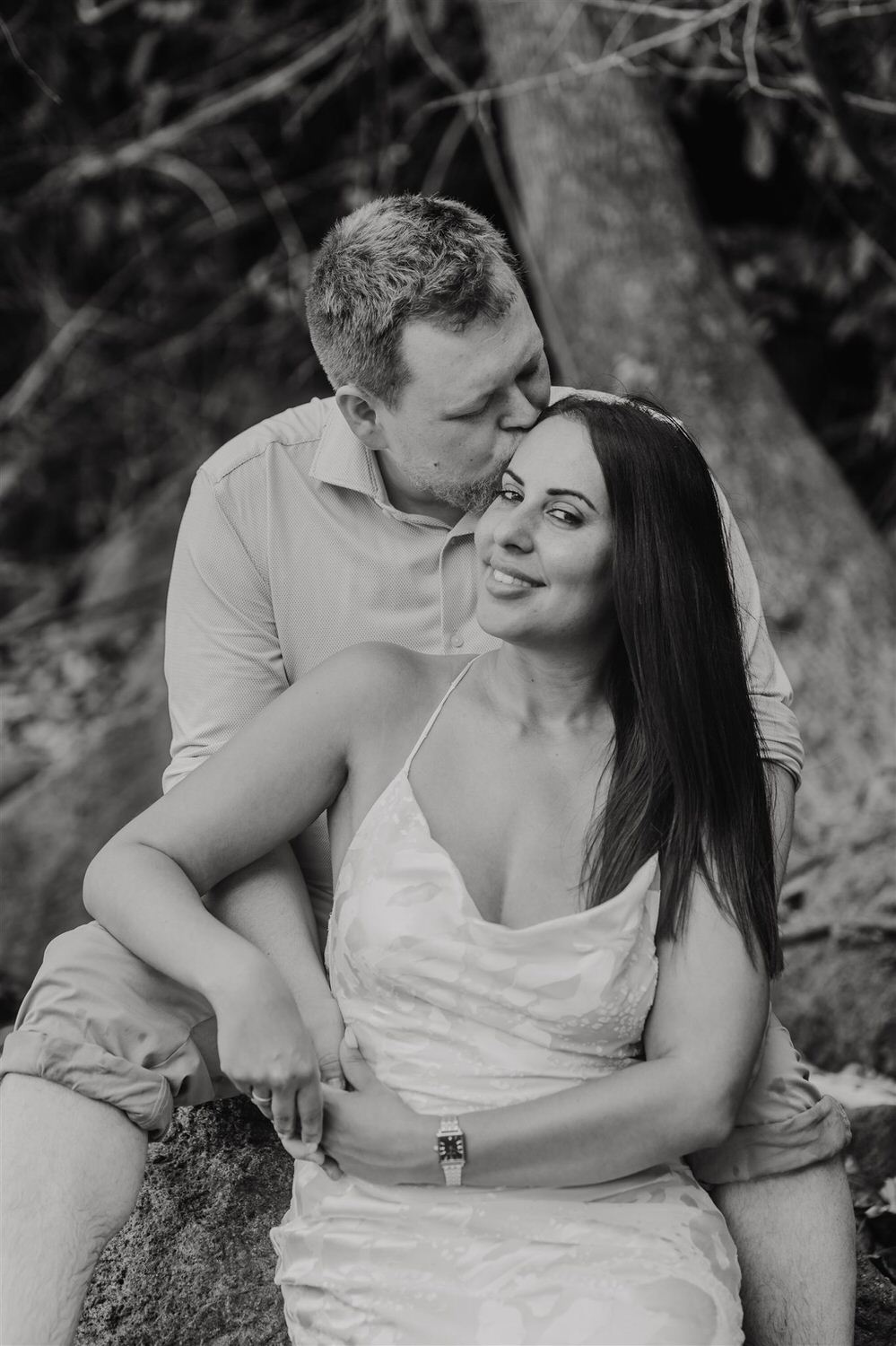 black and white image of couple sitting on rocks on sugar beach in saint lucia destination photography