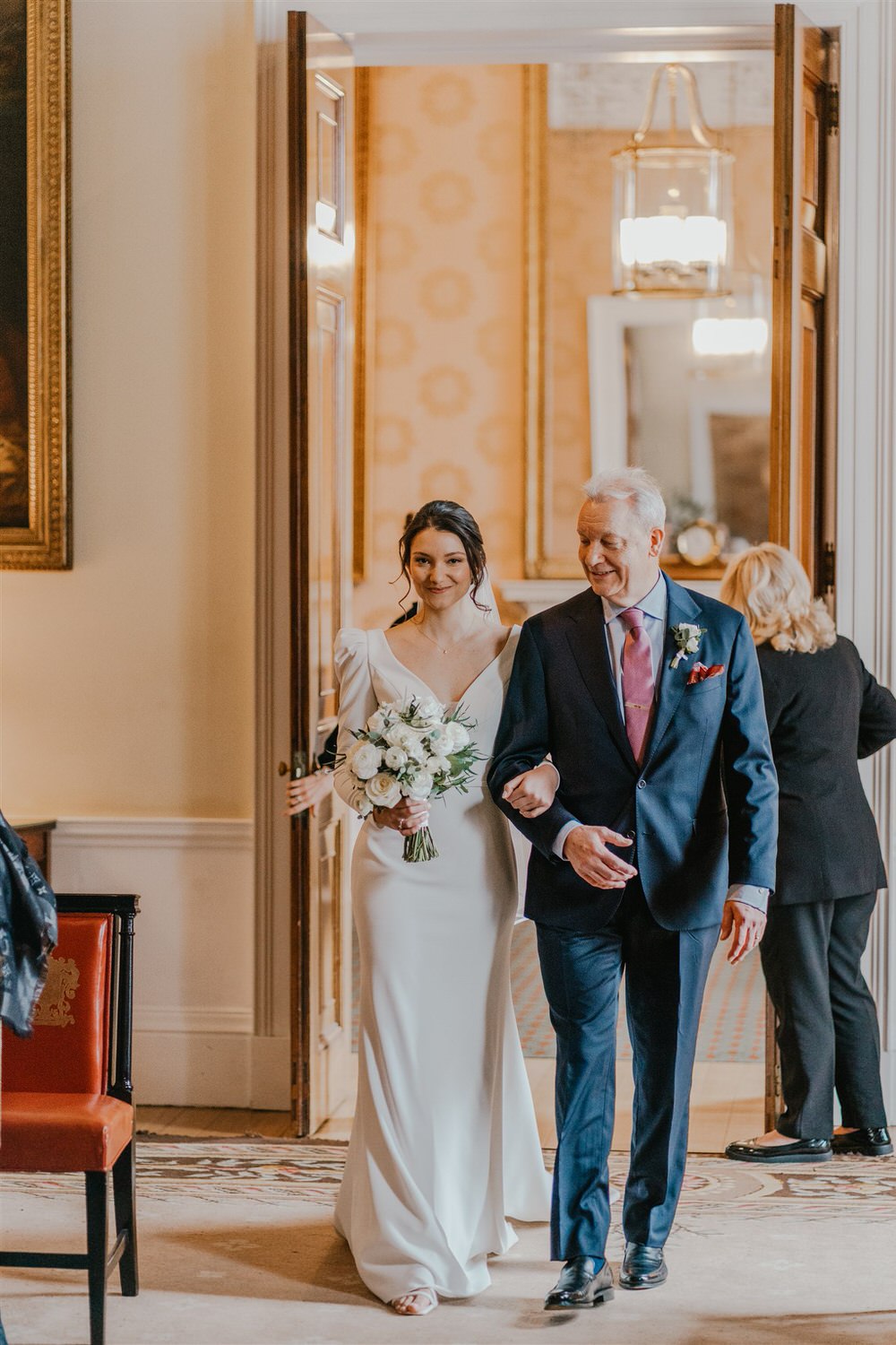 bride and her father walk down the aisle at trinity house in london winter wedding