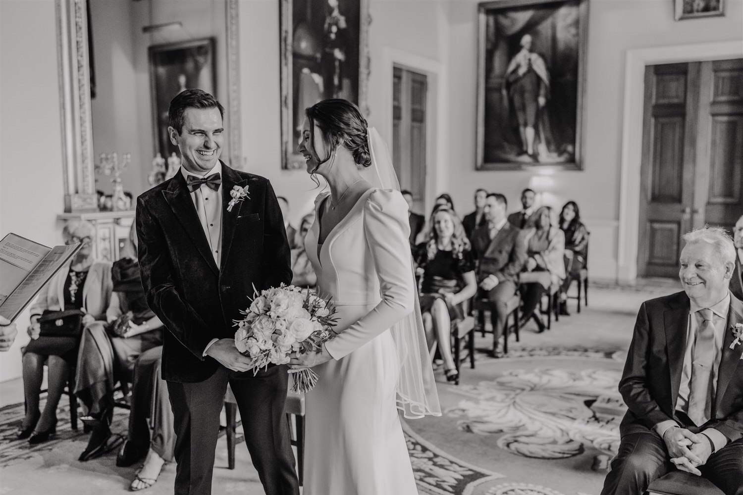 black and white bride and groom laugh during ceremony at trinity house winter wedding in london