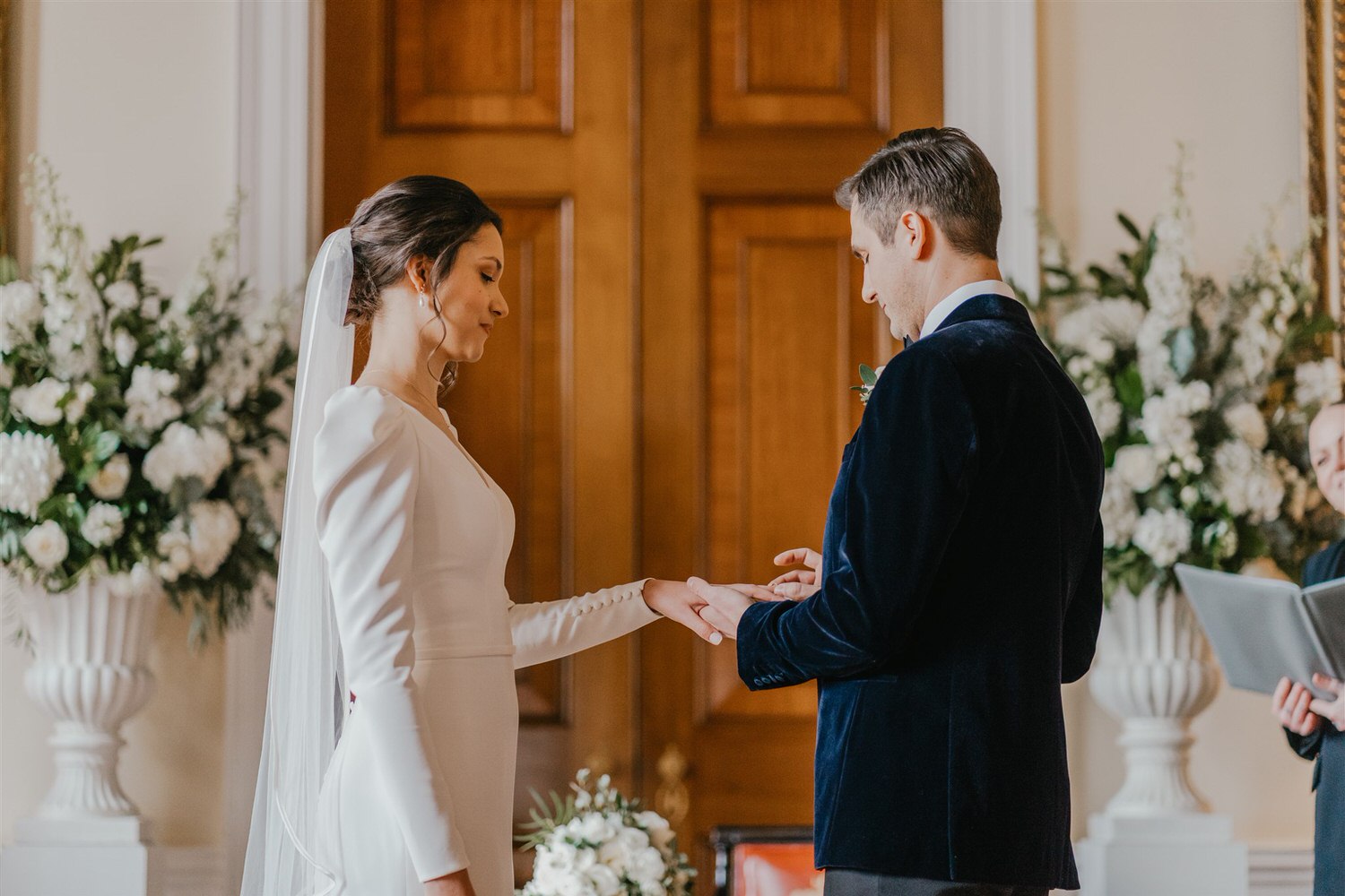 bride and groom exchange rings at trinity house winter wedding in london