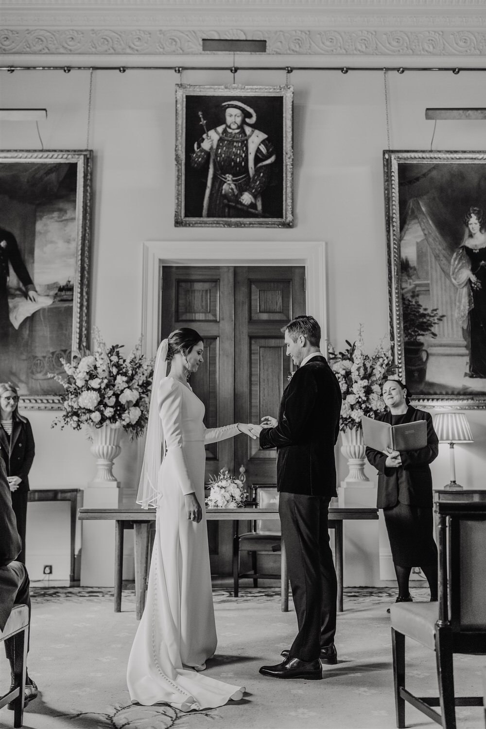 black and white photo as bride and groom exchange rings at trinity house winter wedding in london