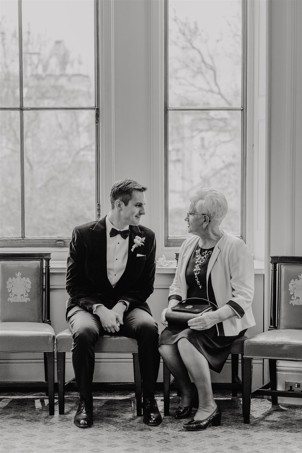 groom candids during drinks reception in the library at trinity house in london