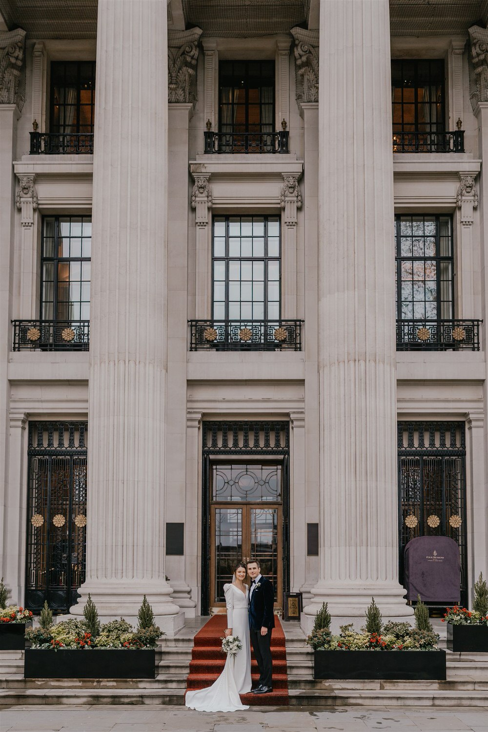 bride and groom couple portraits outside the four seasons hotel near tower bridge at winter wedding in london