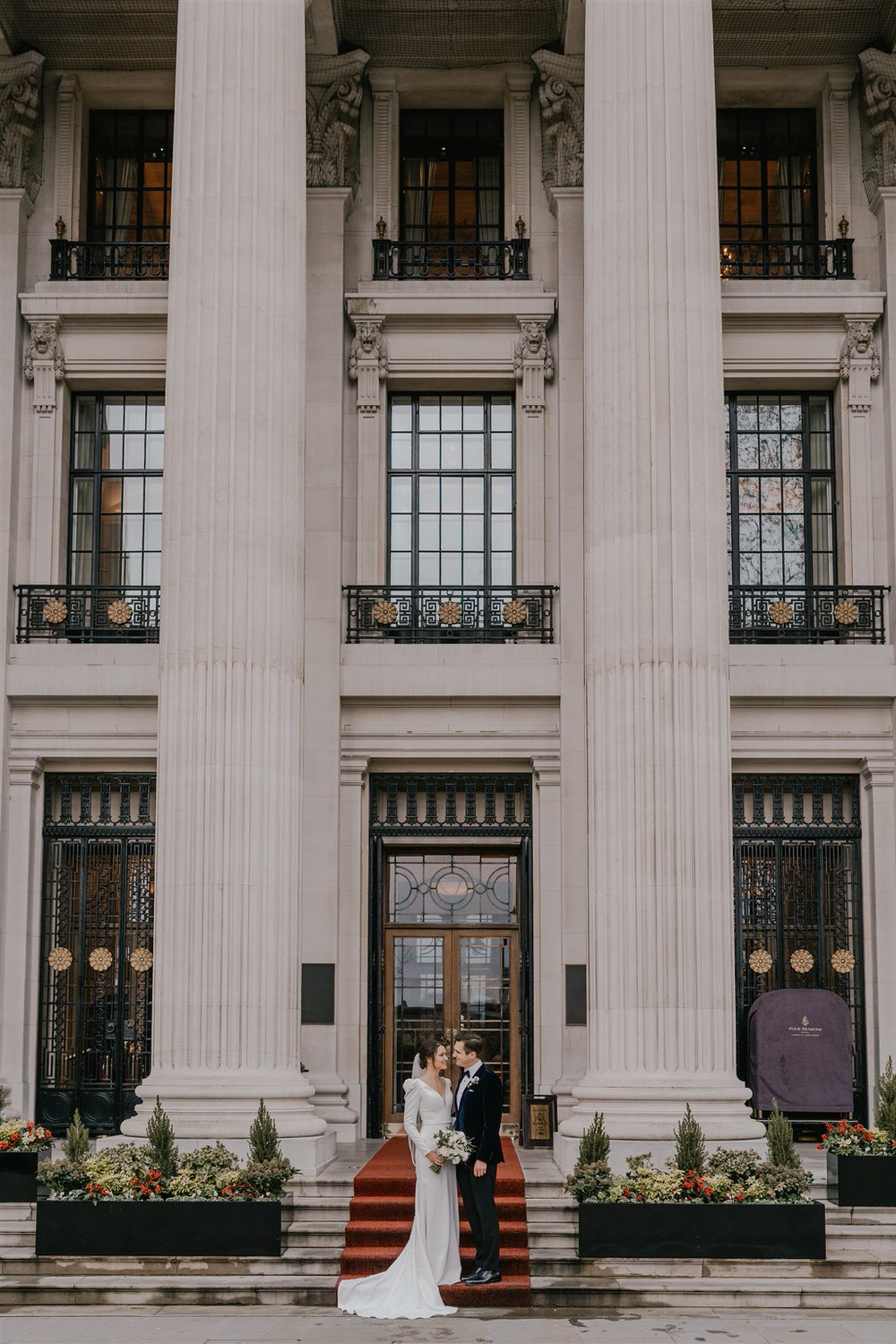bride and groom couple portraits outside the four seasons hotel near tower bridge at winter wedding in london