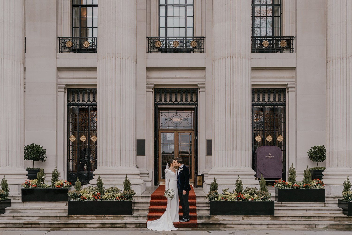 bride and groom couple portraits outside the four seasons hotel near tower bridge at winter wedding in london