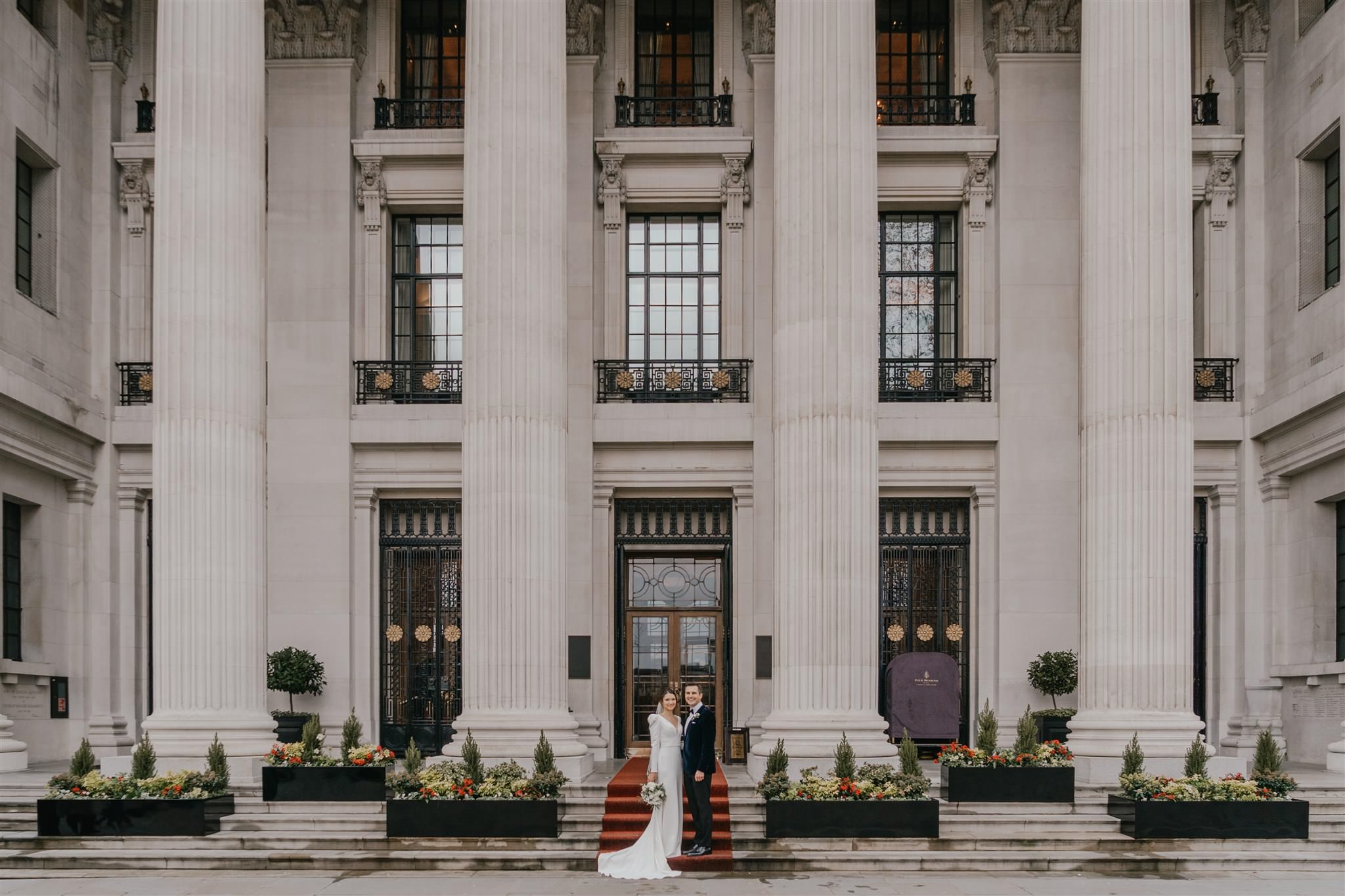 bride and groom couple portraits outside the four seasons hotel near tower bridge at winter wedding in london